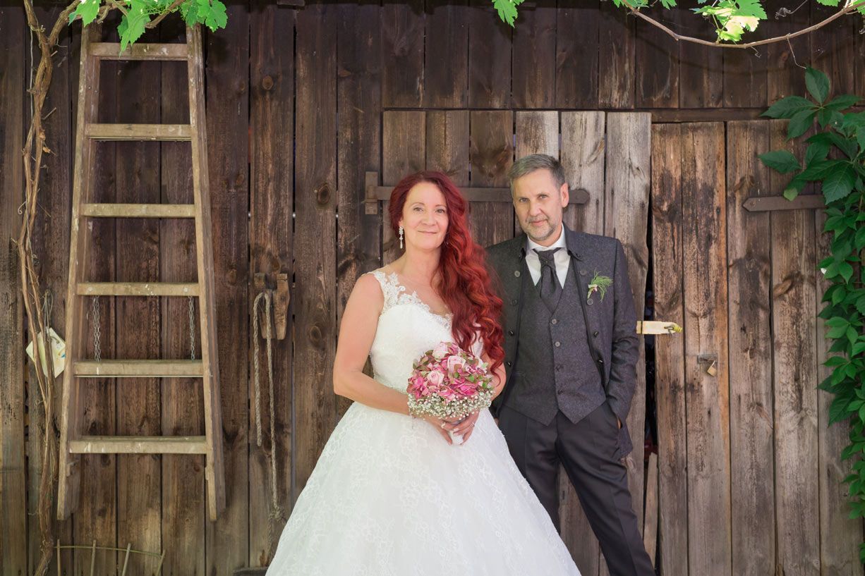 Brautpaar vor einer rustikalen Holzwand bei ihrer Hochzeit im Landhaus Himmelpfort am See.