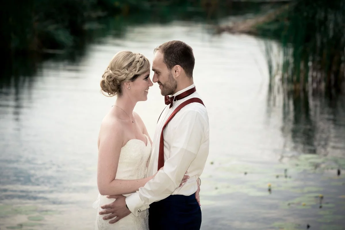 Hochzeit Seelodge Kremmen - Zärtlicher Moment des Brautpaares am Wasser, während sie sich tief in die Augen schauen.