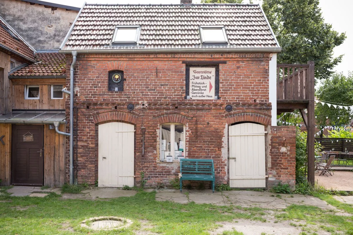 ochzeitslocation Haus am Bauernsee mit rustikaler Backsteinfassade und nostalgischem Schild der Gaststätte 