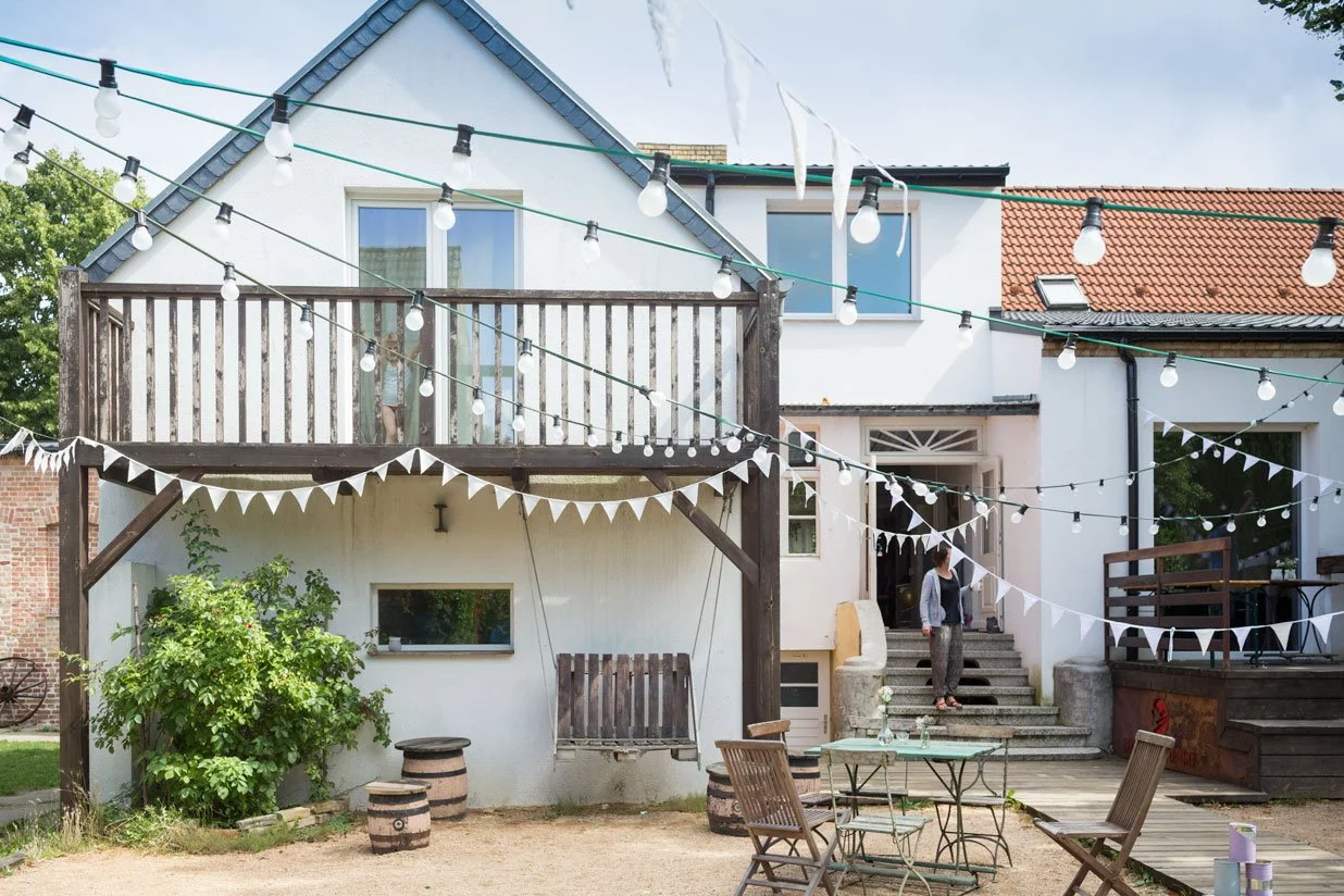 Hochzeitsscheune im Haus am Bauernsee mit rustikaler Backsteinfassade und grüner Bank.