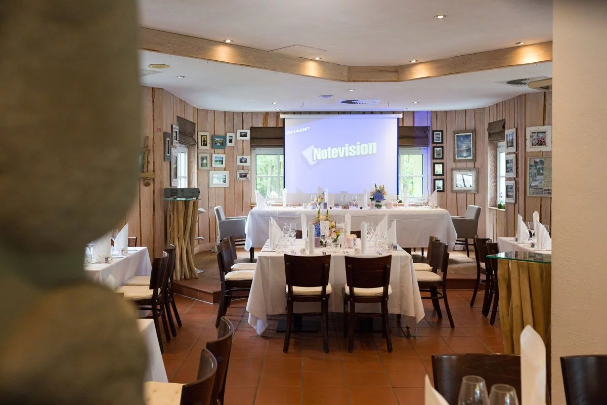 Innenansicht der Seelodge Kremmen mit einem festlich gedeckten Bankettsaal für eine Hochzeit, rustikale Holzdekoration und natürliches Licht.

