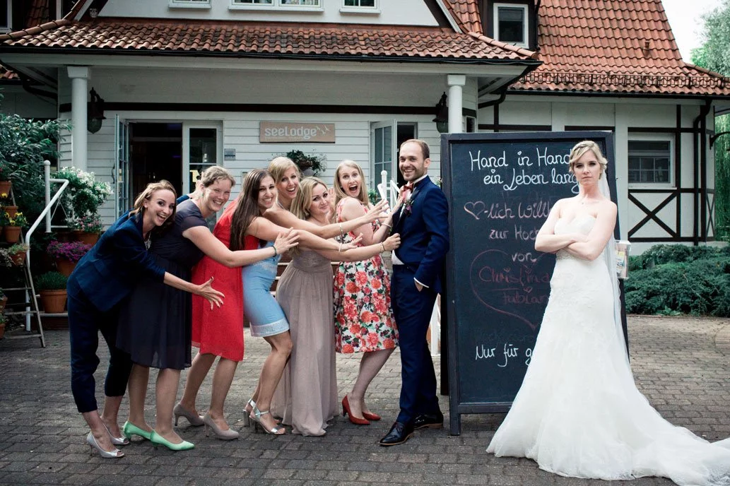 Brautpaar mit Brautjungfern vor der Seelodge Kremmen in einem humorvollen Moment.