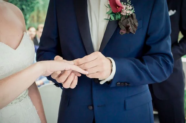 Der Bräutigam steckt seiner Braut den Ring während der Hochzeit an der Seelodge Kremmen an.