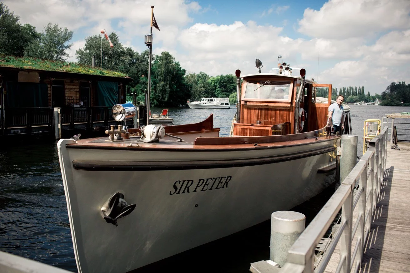 Ein klassisches Holzboot liegt am Steg, bereit für die Fahrt.
