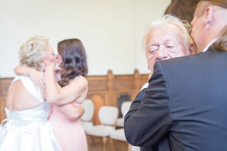 Emotionale Umarmungen während einer Hochzeit im Standesamt Schmargendorf, die die tiefe Verbindung zwischen Gästen und Brautpaar zeigen.