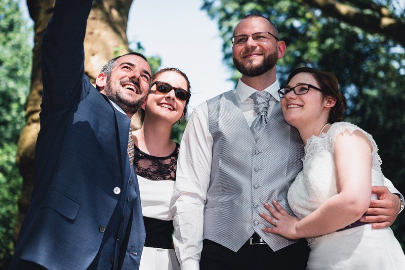 Gruppenfoto mit Hochzeitsfotograf in Berlin – Brautpaar und Freunde lächeln in die Kamera