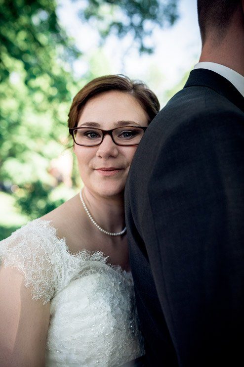 Intimes Porträt der Braut, die sich an die Schulter des Bräutigams lehnt
